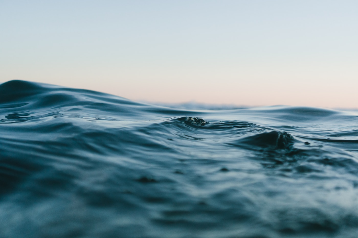 Blue ocean water beneath a pale evening sky